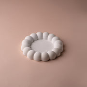 Modern white bubble edge ceramic plate on a beige background